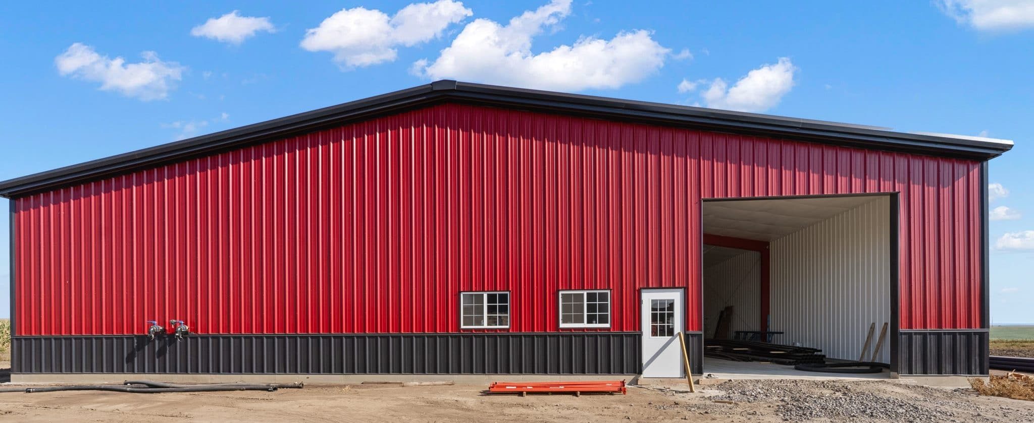 barn with red metal siding and charcoal wainscotting