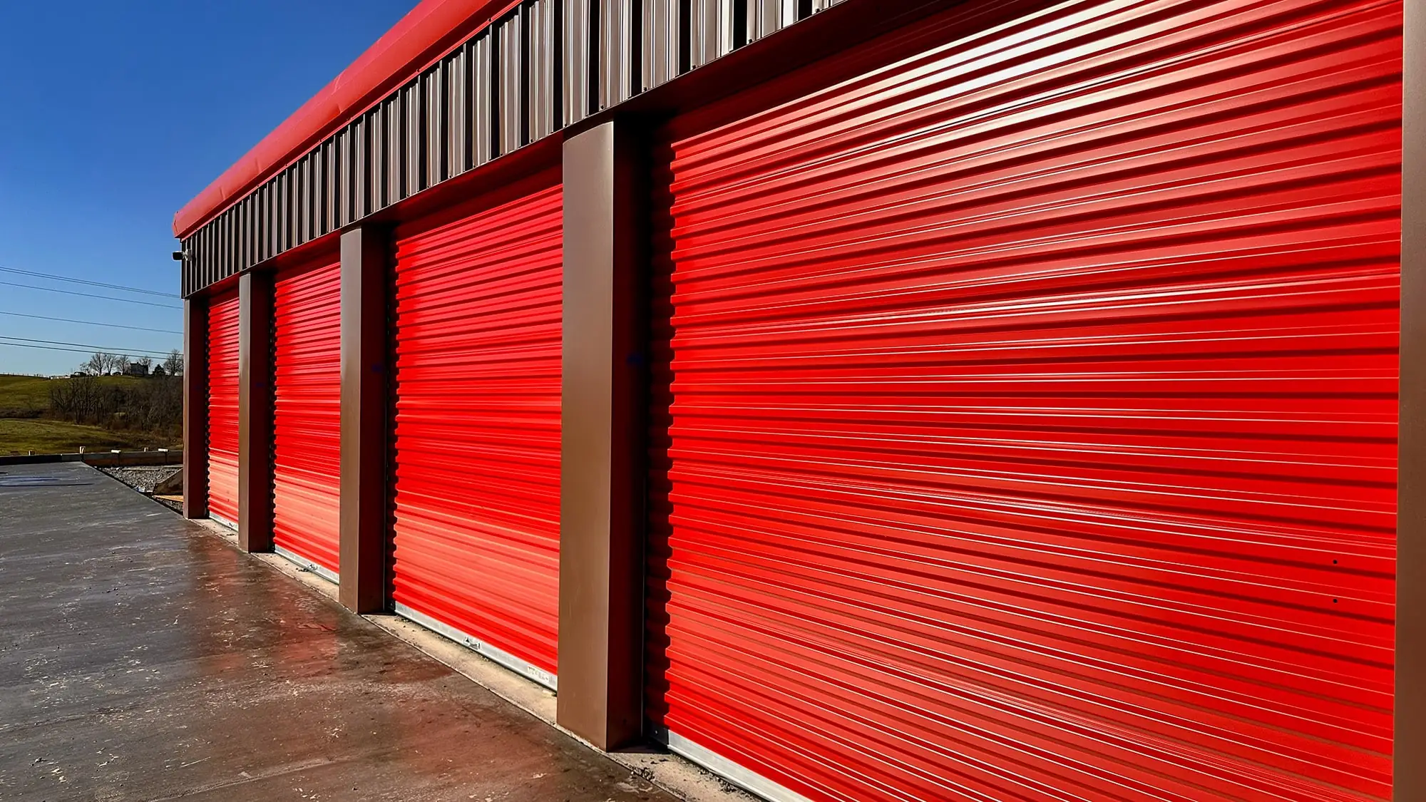 Roll up Doors in Patriot Red with brown siding on a storage building