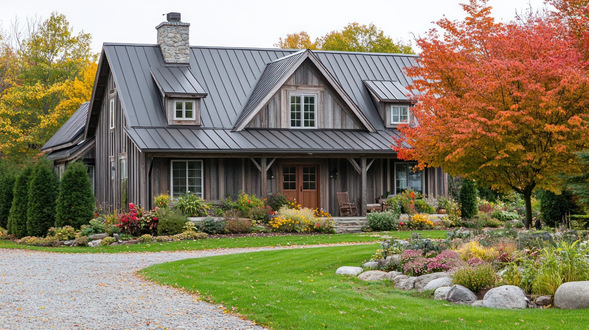 A rustic wooden cabin with a metal roof, surrounded by colorful autumn foliage and a stone pathway.