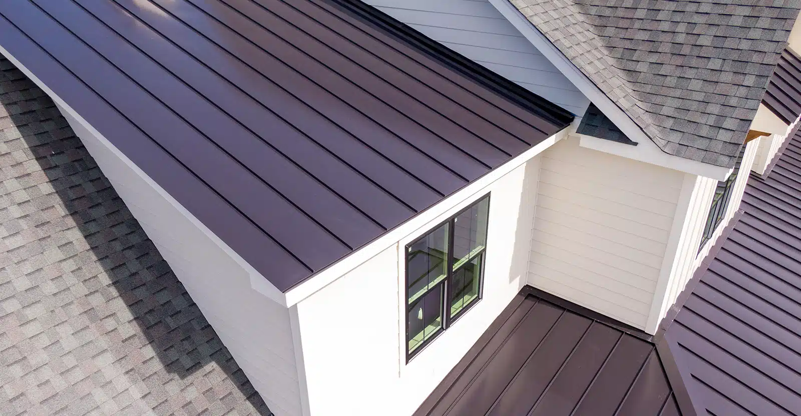 A residential home with metal roofing and asphalt shingles